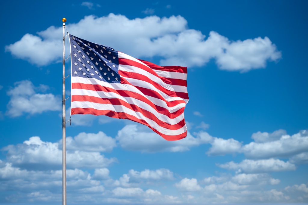 An American flag with the sky in the background