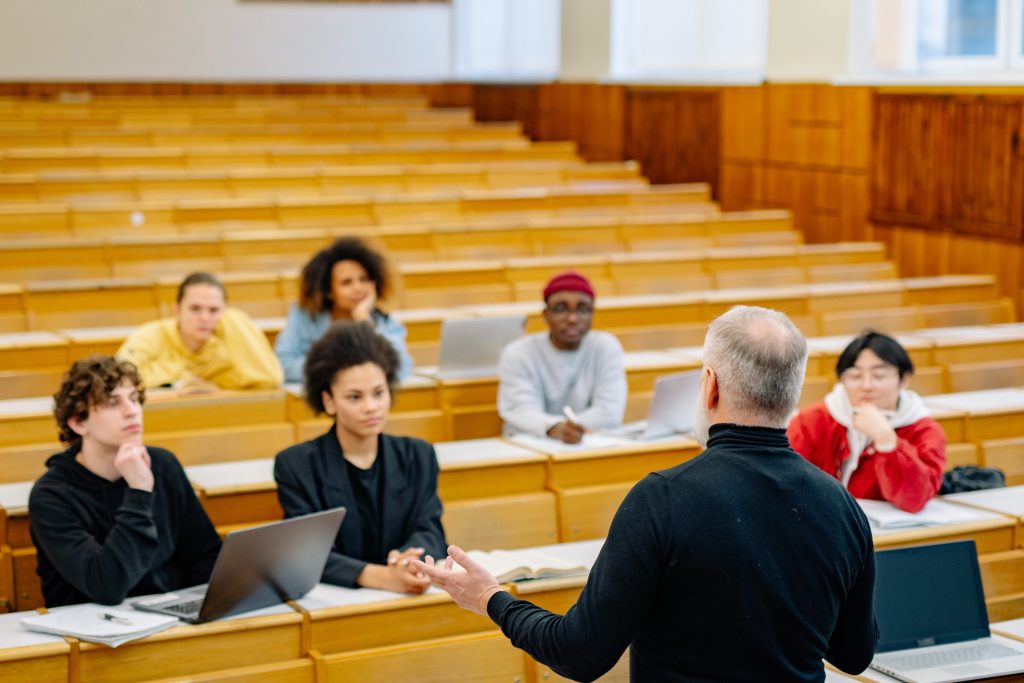 Image of a lecture hall with a professor and students