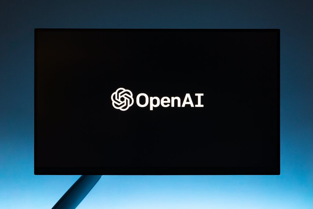 OpenAI logo shown on computer screen with blue light in the background