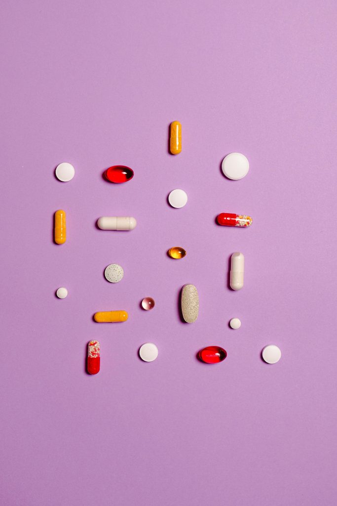 Medication scattered on a purple background