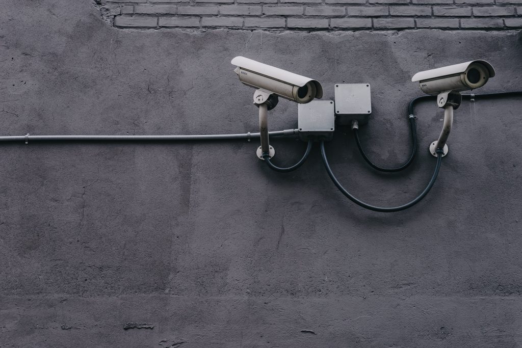 a pair of security cameras on a gray wall