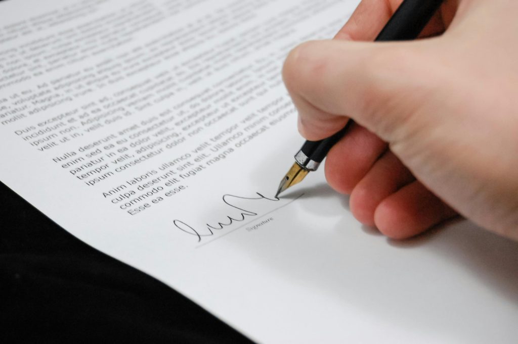 Image of a person signing a document